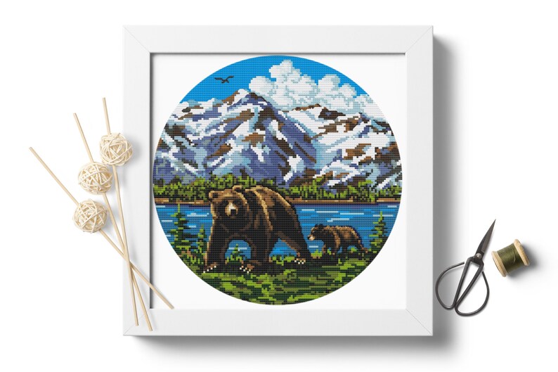Pu&ograve; includere: Un motivo di punto croce rotondo con un orso bruno e un cucciolo che camminano in un ambiente boschivo. Lo sfondo include un lago blu, alberi verdi e montagne innevate.
