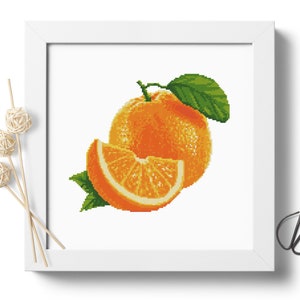 May include: A cross-stitch pattern of a whole orange and a slice of orange with green leaves.