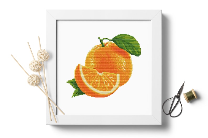 May include: A cross-stitch pattern of a whole orange and a slice of orange with green leaves.