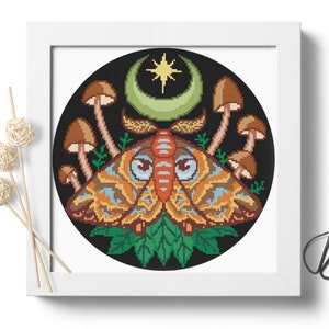 May include: A cross-stitch pattern featuring a colorful moth with large eyes, surrounded by mushrooms and a crescent moon with a star. The design is set against a black background.