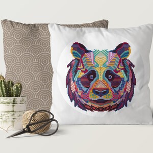 Pu&ograve; includere: Un cuscino bianco con un design di panda geometrico colorato. Il panda &egrave; circondato da un cerchio bianco sul cuscino.