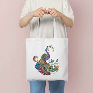 May include: A white tote bag featuring a colourful peacock design printed on the front. The peacock is made up of various geometric shapes and patterns.