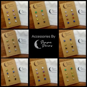 May include: Nine sets of small, colourful, crystal stud earrings on brown cards with the words "Pamper Dreams" printed on them. Each set has a different colour combination of crystals.