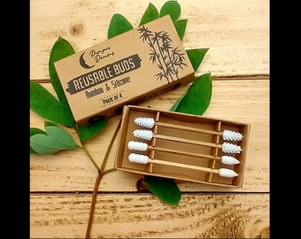 May include: A box of reusable bamboo and silicone ear buds. The box is brown with the words "REUSABLE BUDS" and "Bamboo & Silicone" printed on it. The box contains four ear buds with white silicone tips.