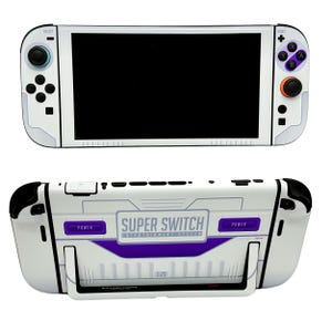 Pode incluir: Sistema de entretenimento Super Switch branco e roxo. A consola de jogos portátil tem um corpo branco com detalhes roxos e a inscrição "Super Switch" na parte de trás. Os botões do controlador são roxos e laranja.
