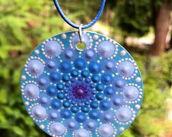 Hand painted mandala necklace in soft blues and lavender on a cord.