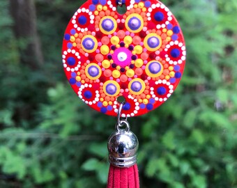 Hand painted mandala design on wood with tassel and cord done in happy bright colors to create a pretty necklace of wearable art.