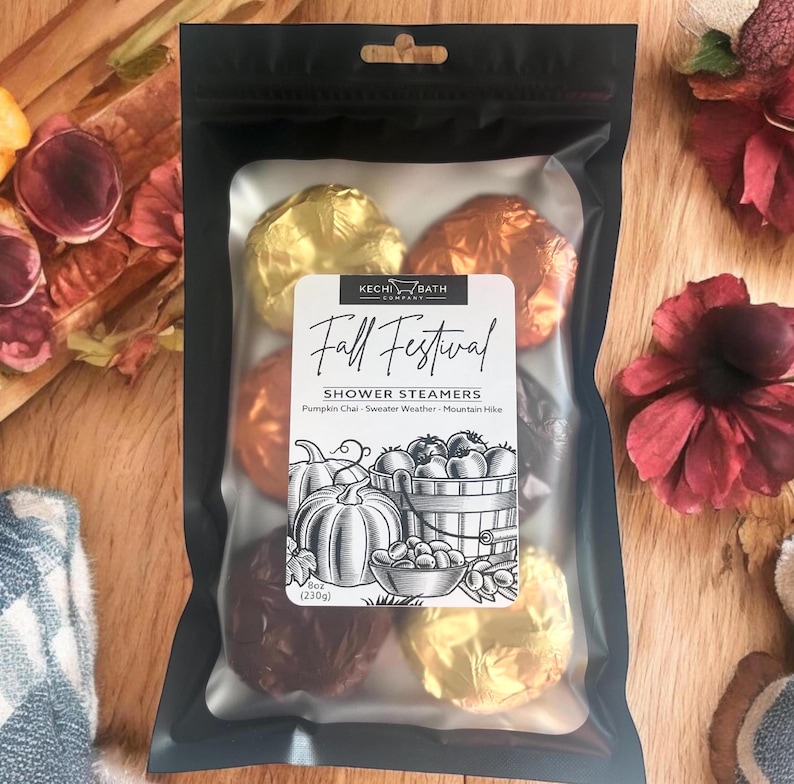 This is a black mylar bag with a clear front window with label on the front with b+w fall line art. Inside are 3 kinda of shower steamers, foil-wrapped in brown, gold, and orange and in seasonal scents - individually labeled with directions.