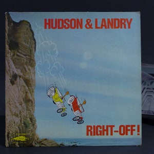 May include: Vintage LP record album cover featuring the title "HUDSON & LANDRY" in red text. The album art depicts two cartoon cars falling off a cliff, with the words "RIGHT-OFF!" below. The background is a blue sky and ocean.