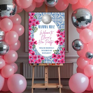 Può includere: Un arco di palloncini rosa con sfere da discoteca argentate e un cartello con la scritta "Mamma Mia! Benvenuta all'addio al nubilato di Olivia!" Il cartello è su un cavalletto di legno e circondato da fiori rosa.