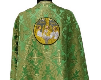 May include: Green liturgical vestment with a gold embroidered design of crosses and a circular icon depicting the Holy Trinity. The icon is surrounded by a gold border.
