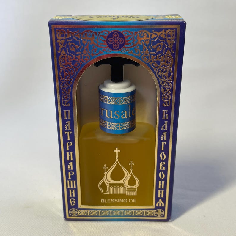 May include: A rectangular box with a blue and gold design, containing a bottle of Blessing Oil. The bottle has a black top and a blue and white label that says "Jerusalem". The box has text in a foreign language.
