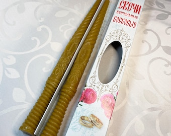 May include: Two yellow beeswax candles with a cross design, packaged in a white box with a floral pattern and the text "Свечи  церковные  восковые".
