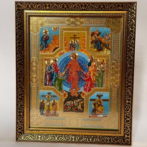 May include: A framed religious icon with a gold and black ornate border. The icon features multiple scenes with figures in robes, a central figure in red, and gold accents. The background is a mix of blue and gold.