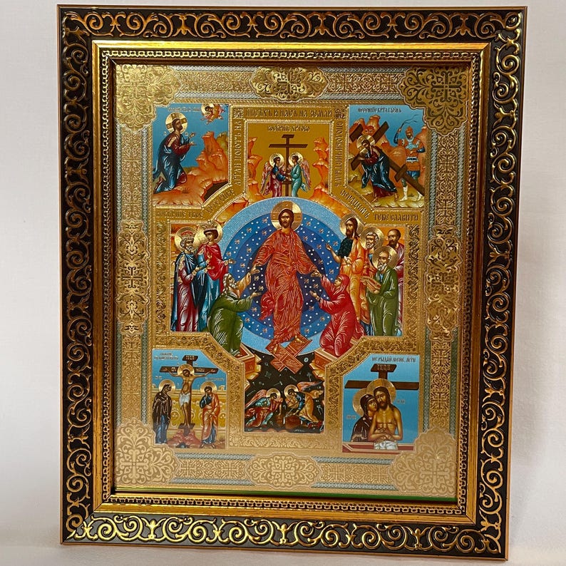 May include: A framed religious icon with a gold and black ornate border. The icon features multiple scenes with figures in robes, a central figure in red, and gold accents. The background is a mix of blue and gold.