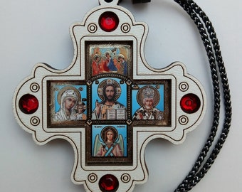 May include: A wooden cross with a white background and four small images of religious figures. The cross has red gem accents and a black cord.