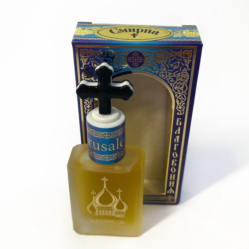 May include: A square glass bottle of Blessing Oil with a black cross-shaped stopper. The bottle has a gold label with church domes. The box is blue with gold accents and Cyrillic text.