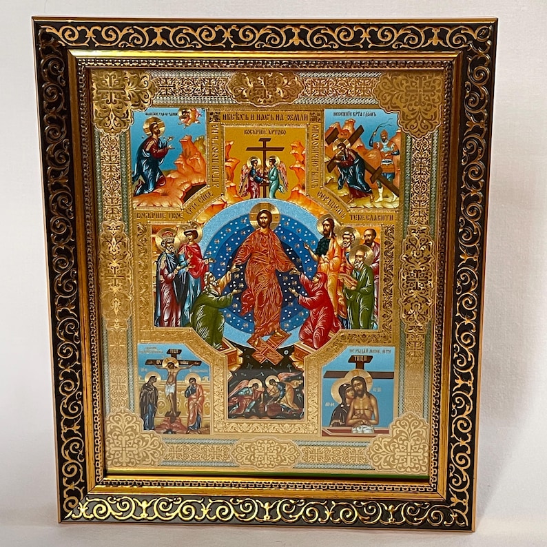 May include: A framed religious icon with a gold and black ornate border. The icon features a central image of a figure in red robes surrounded by other figures. The background includes blue and gold accents, with additional religious scenes depicted.