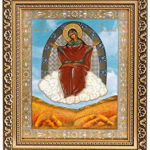Op de afbeelding: Een icoon van de Maagd Maria, afgebeeld in een gouden lijst met een blauwe achtergrond. Ze zit op een wolk met haar armen uitgestrekt, omringd door een halo van licht. Het icoon is geplaatst tegen een veld met tarwe.