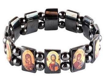 May include: A black bracelet with small black beads and rectangular charms featuring religious icons. The icons are colorful and depict Jesus and Mary.