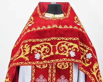 May include: A red velvet liturgical vestment with gold and white embroidery. The vestment has a decorative floral pattern and a cross design.