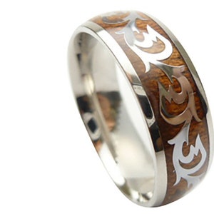 May include: A silver ring with a brown wood inlay featuring a silver tribal design.