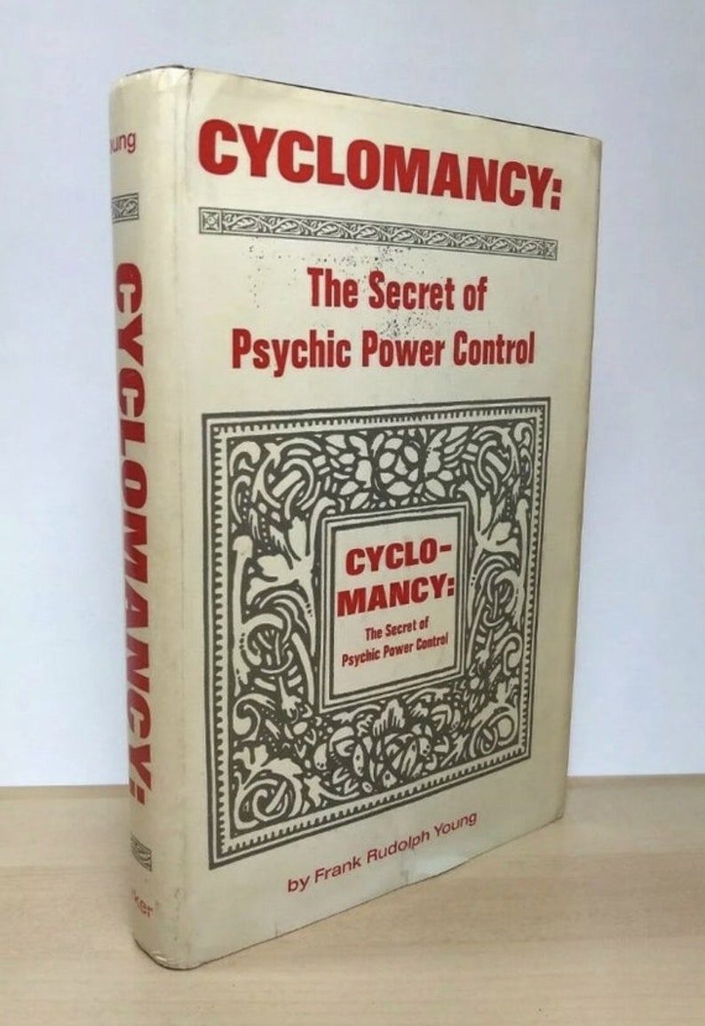 Może przedstawiać: Zabytkowa książka zatytułowana "CYCLOMANCY: The Secret of Psychic Power Control" autorstwa Franka Rudolpha Younga. Książka ma kremową okładkę z czerwonym i czarnym tekstem. Tytuł jest wyraźnie wyświetlany dużymi czerwonymi literami.