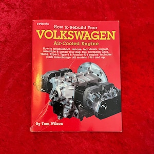 May include: A red book titled "How to Rebuild Your Volkswagen Air-Cooled Engine" by Tom Wilson. The book cover features a detailed image of an air-cooled engine. The book covers models from 1961 and up.