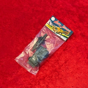 May include: A plastic bag containing two gray toy army vehicle parts, including a trailer and a chassis. The packaging features a header card with the text "ARMY VEHICLES" and an illustration of military trucks in yellow and green colors.