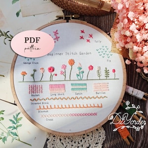 May include: A white embroidery hoop featuring a beginner stitch garden design. The hoop showcases a range of stitches, such as back stitch, long and short stitch, satin stitch, and bullion stitch. The hoop also includes various floral designs, including tulips, fly, and George Cross.