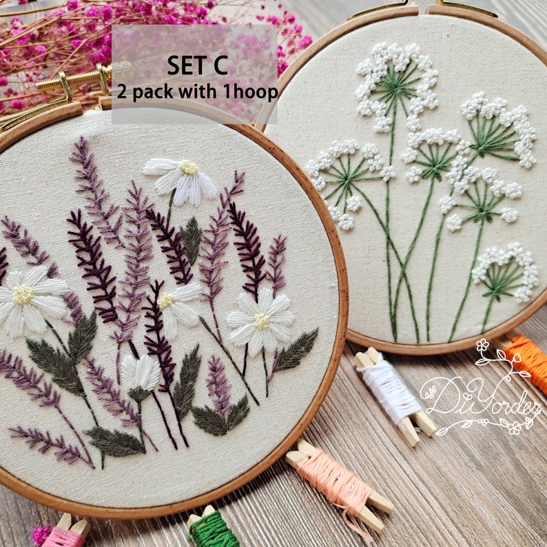 Peut inclure: Deux cerceaux &agrave; broder avec des motifs floraux. Le cerceau de gauche pr&eacute;sente des marguerites blanches, de la lavande violette et des feuilles vertes. Le cerceau de droite pr&eacute;sente des fleurs blanches avec des tiges vertes. Le texte "SET C 2 pack with 1 hoop" est visible sur l'image.