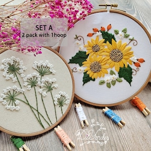 Peut inclure: Kit de broderie Set A avec deux motifs, l'un avec des fleurs blanches et l'autre avec des tournesols jaunes. Le kit comprend deux cerceaux &agrave; broder, du fil &agrave; broder et des aiguilles.