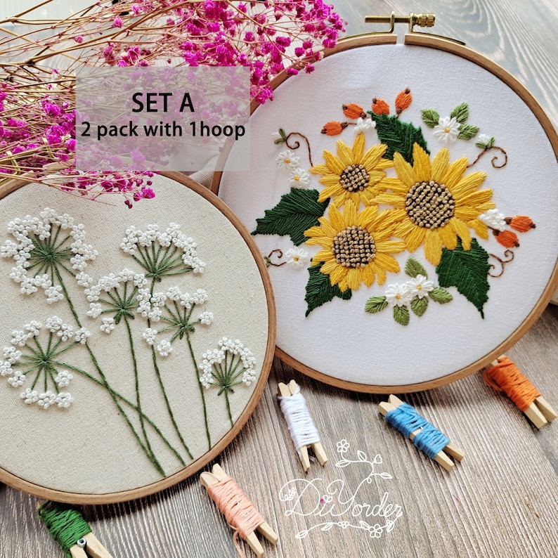 Peut inclure: Kit de broderie Set A avec deux motifs, l'un avec des fleurs blanches et l'autre avec des tournesols jaunes. Le kit comprend deux cerceaux &agrave; broder, du fil &agrave; broder et des aiguilles.