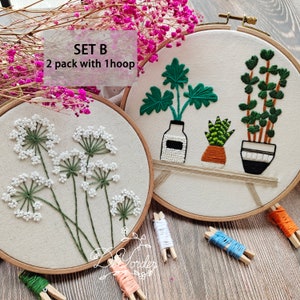 Peut inclure: Deux cerceaux &agrave; broder avec des motifs floraux diff&eacute;rents. Le premier cerceau pr&eacute;sente une fleur blanche avec des tiges vertes. Le deuxi&egrave;me cerceau pr&eacute;sente une plante verte dans un pot blanc, une plante verte dans un pot brun et une plante verte dans un pot noir et blanc. Le texte "SET B 2 pack with 1 hoop" est visible sur l'image.