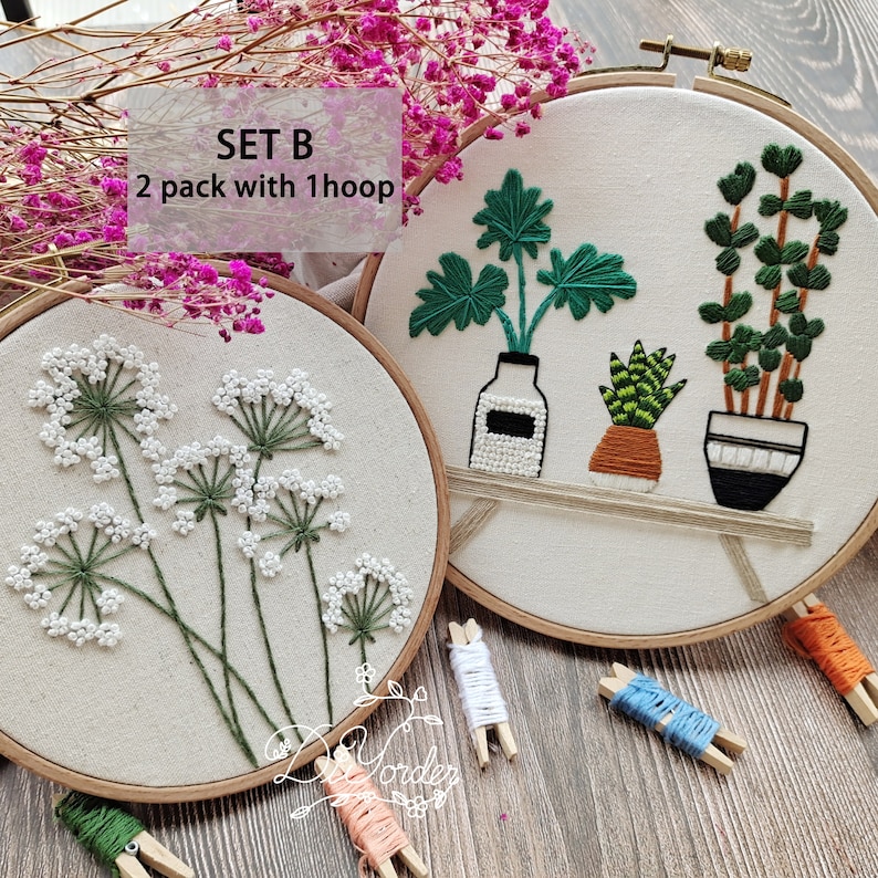 Peut inclure: Deux cerceaux &agrave; broder avec des motifs floraux diff&eacute;rents. Le premier cerceau pr&eacute;sente une fleur blanche avec des tiges vertes. Le deuxi&egrave;me cerceau pr&eacute;sente une plante verte dans un pot blanc, une plante verte dans un pot brun et une plante verte dans un pot noir et blanc. Le texte "SET B 2 pack with 1 hoop" est visible sur l'image.