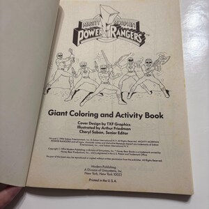 May include: A black and white coloring book cover featuring the Mighty Morphin Power Rangers characters. The cover text reads "Giant Coloring and Activity Book".
