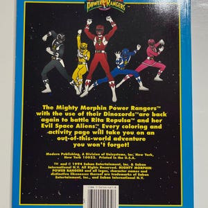 May include: The Mighty Morphin Power Rangers coloring book cover features a group of five Power Rangers in their colorful suits, standing in a fighting pose against a black starry background. The text "Mighty Morphin Power Rangers" is in a blue box at the top of the cover.