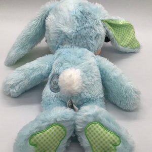 K&ouml;nnte beinhalten: Ein blauer Pl&uuml;schhase mit gr&uuml;n-wei&szlig; karierten Ohren und F&uuml;&szlig;en. Der Hase hat einen wei&szlig;en, flauschigen Schwanz und ein Disney Store-Etikett auf dem R&uuml;cken.
