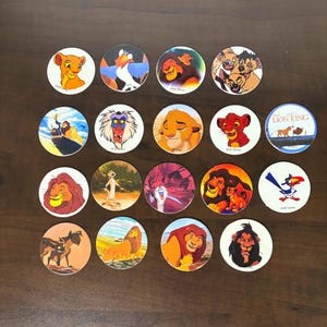 May include: A collection of nineteen circular cardboard discs featuring colorful illustrations of characters from The Lion King, including Simba, Mufasa, Scar, Timon, Pumbaa, Zazu, and Rafiki, with some discs displaying the Walt Disney copyright text.