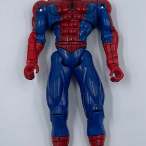 Puede incluir: Una figura de acci&oacute;n de pl&aacute;stico roja y azul de Spider-Man. La figura tiene un dise&ntilde;o detallado con un traje rojo y azul, un logotipo de ara&ntilde;a en el pecho y un patr&oacute;n de telara&ntilde;a blanca en las piernas y los brazos.
