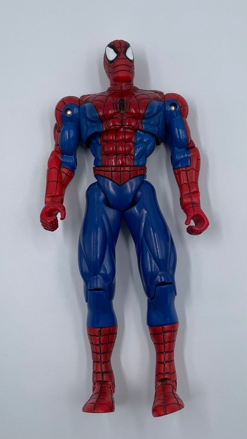 Puede incluir: Una figura de acci&oacute;n de pl&aacute;stico roja y azul de Spider-Man. La figura tiene un dise&ntilde;o detallado con un traje rojo y azul, un logotipo de ara&ntilde;a en el pecho y un patr&oacute;n de telara&ntilde;a blanca en las piernas y los brazos.