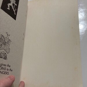 May include: A vintage book with black and white illustrations. The book is open to a page with a drawing of a monster and the text "gives the COINS to the RANGERS."