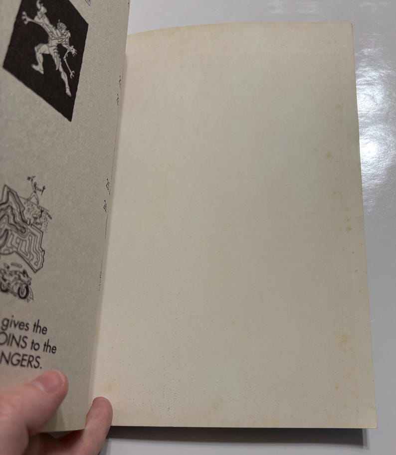 May include: A vintage book with black and white illustrations. The book is open to a page with a drawing of a monster and the text "gives the COINS to the RANGERS."