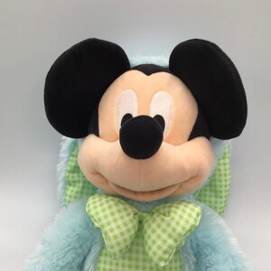 K&ouml;nnte beinhalten: Ein blauer Pl&uuml;sch-Mickey Mouse mit einer gr&uuml;n-wei&szlig; karierten Schleife. Das Pl&uuml;schtier ist in ein blaues Hasenkost&uuml;m mit einem gr&uuml;n-wei&szlig; karierten Kragen gekleidet.