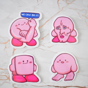 Pu&ograve; includere: Quattro adesivi rosa e bianchi con un personaggio dei cartoni animati con diverse espressioni e pose. Un adesivo ha il testo "We can do it!" in blu.