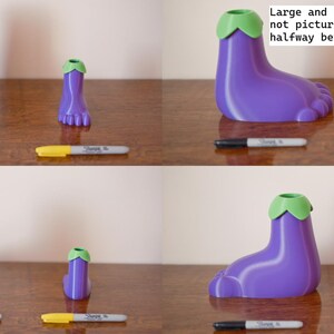 May include: Three purple eggplant-shaped pencil holders with green tops. The holders are in three different sizes: small, medium, and large. The text "Large and Small size, Medium is not pictured here but is halfway between these two sizes" is written on a white background.