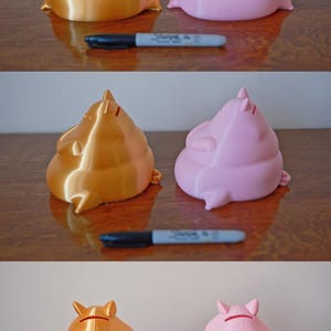 May include: Two piggy banks, one gold and one pink, are sitting on a wooden surface. Both piggy banks are in a seated position with their legs crossed.