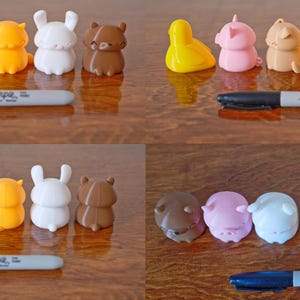 Peut inclure: Un ensemble de 10 petites figurines d'animaux imprim&eacute;es en 3D, de couleurs vives. Les animaux comprennent un cochon, un lapin, un ours, un canard et un chat. Les figurines sont dispos&eacute;es en deux rang&eacute;es de cinq, les animaux faisant face &agrave; l'avant. Les figurines sont faites d'un mat&eacute;riau lisse, semblable au plastique.