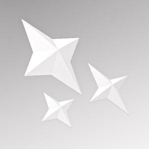 May include: Three white paper stars of different sizes, arranged in a cluster. The stars are folded into a three-dimensional shape, creating a geometric pattern.