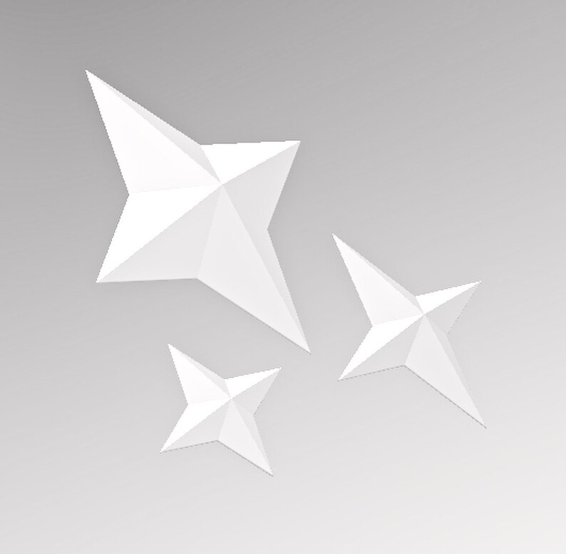 May include: Three white paper stars of different sizes, arranged in a cluster. The stars are folded into a three-dimensional shape, creating a geometric pattern.